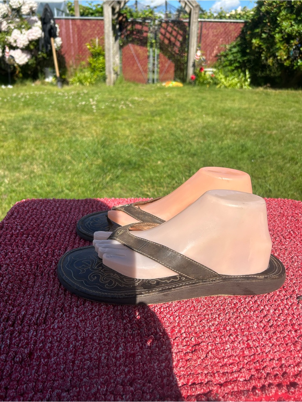 OluKai Paniolo women's sandals featuring dark leather and distinctive saddle